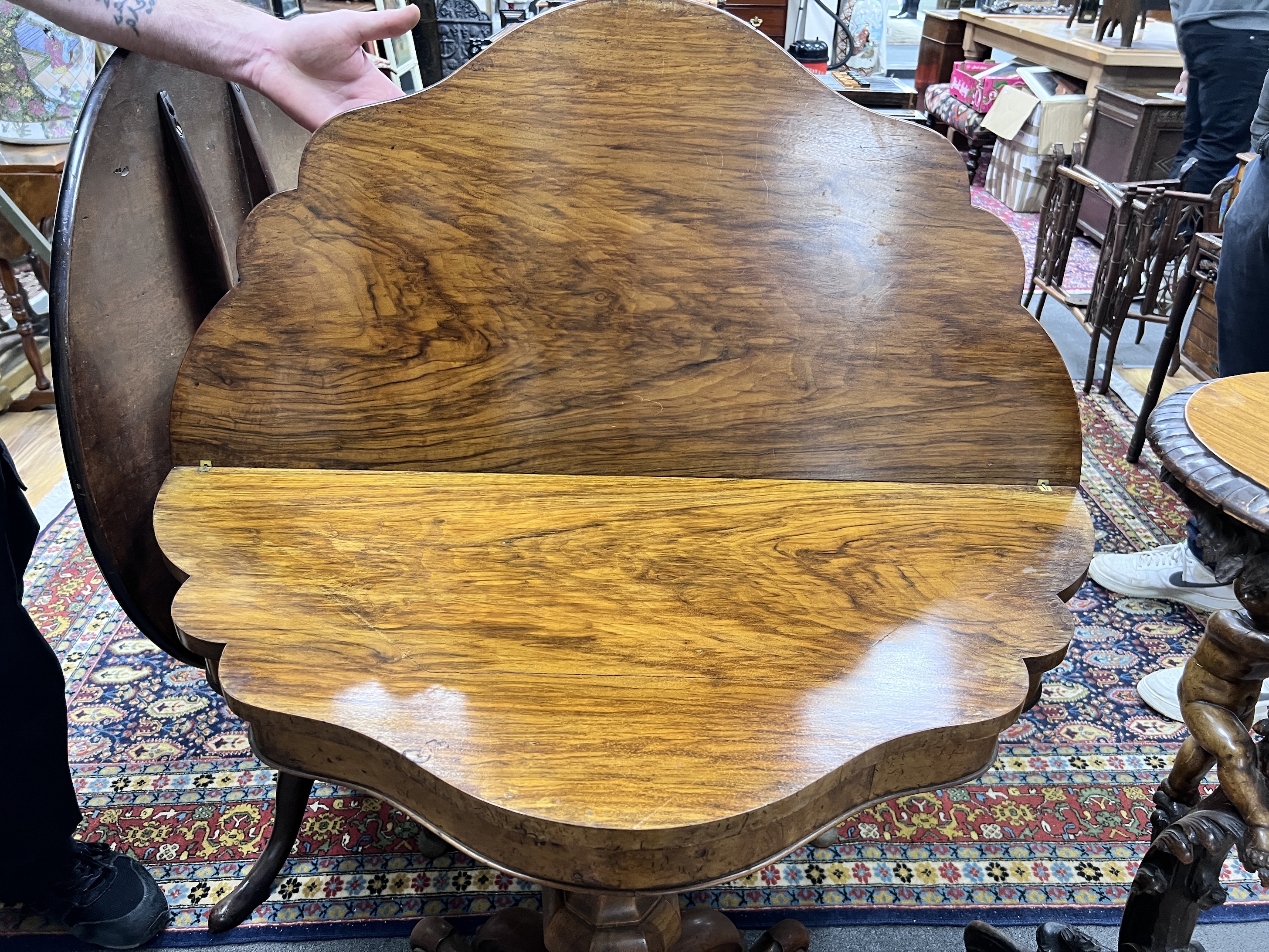 A Victorian walnut demi-lune folding tea table, width 91cm